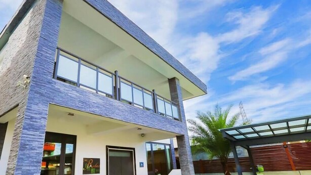 A modern two-story building with a flat roof, large windows, and a covered outdoor area. - Relax B&B (Dongshan)