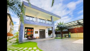 A modern two-story building with a covered outdoor seating area and a paved courtyard. - Relax B&B (Dongshan)