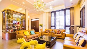 A modern living room with leather sofas, a glass coffee table, and a chandelier. - Relax B&B (Dongshan)