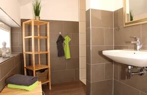 A bathroom with a wooden shelf, a sink, and a mirror. - Bergtraum Braunlage (Braunlage)