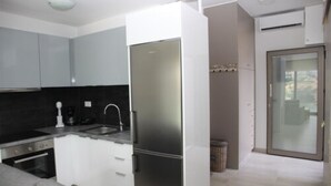 A modern kitchen with a built-in refrigerator, a coffee maker, and a sink. - Villa Maria Sea View by Estia (Mylopotamos)