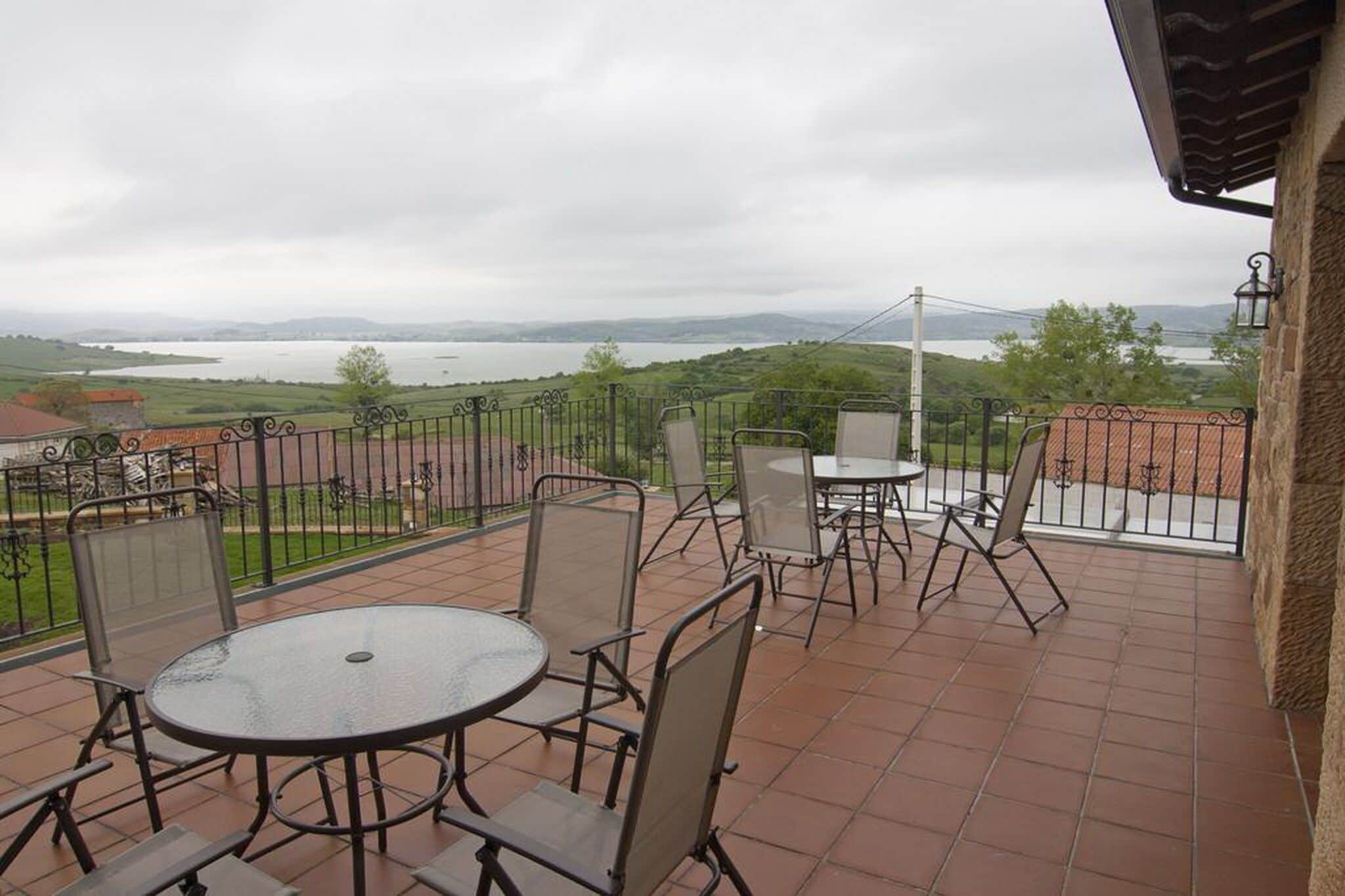 Una terraza con mobiliario exterior y vistas a un lago.