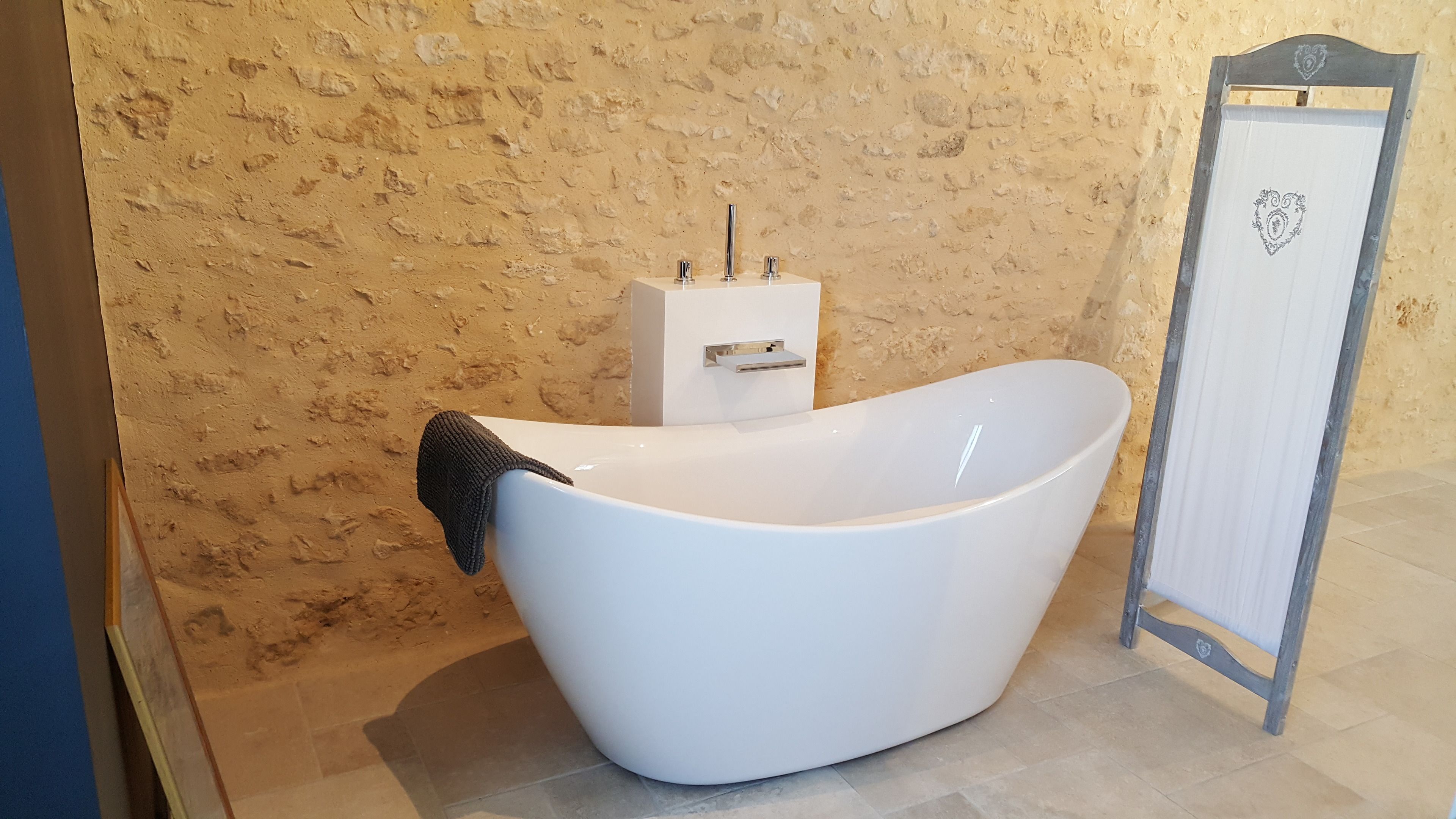 Un bagno moderno con una vasca freestanding, un porta asciugamani e uno specchio con decorazione a forma di cuore.