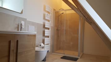 Une salle de bain moderne équipée d’une douche, de toilettes et d’un lavabo.