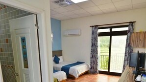 Une chambre d’hôtel avec un lit, un bureau et un balcon avec des rideaux.