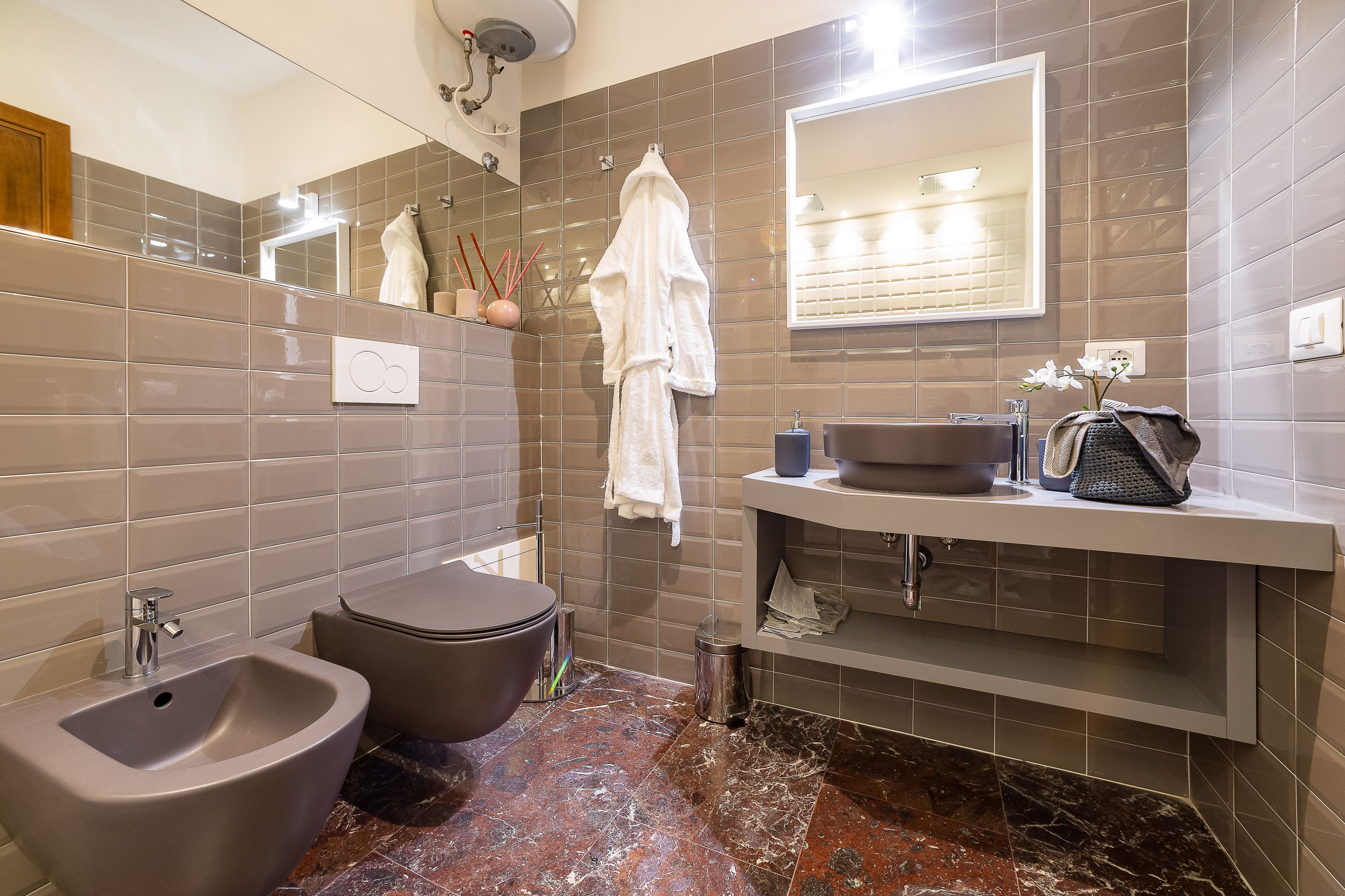 Une salle de bain moderne équipée d’un bidet, d’un lavabo et d’un miroir.