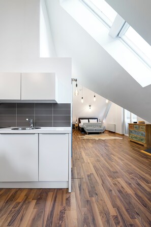 Ein modernes Schlafzimmer im Loft-Stil mit Schräge, integriertem Bett und Dachfenster.