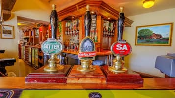 A bar area with three beer taps labeled 'Bitter', 'The Rev. James', and 'SA'.
