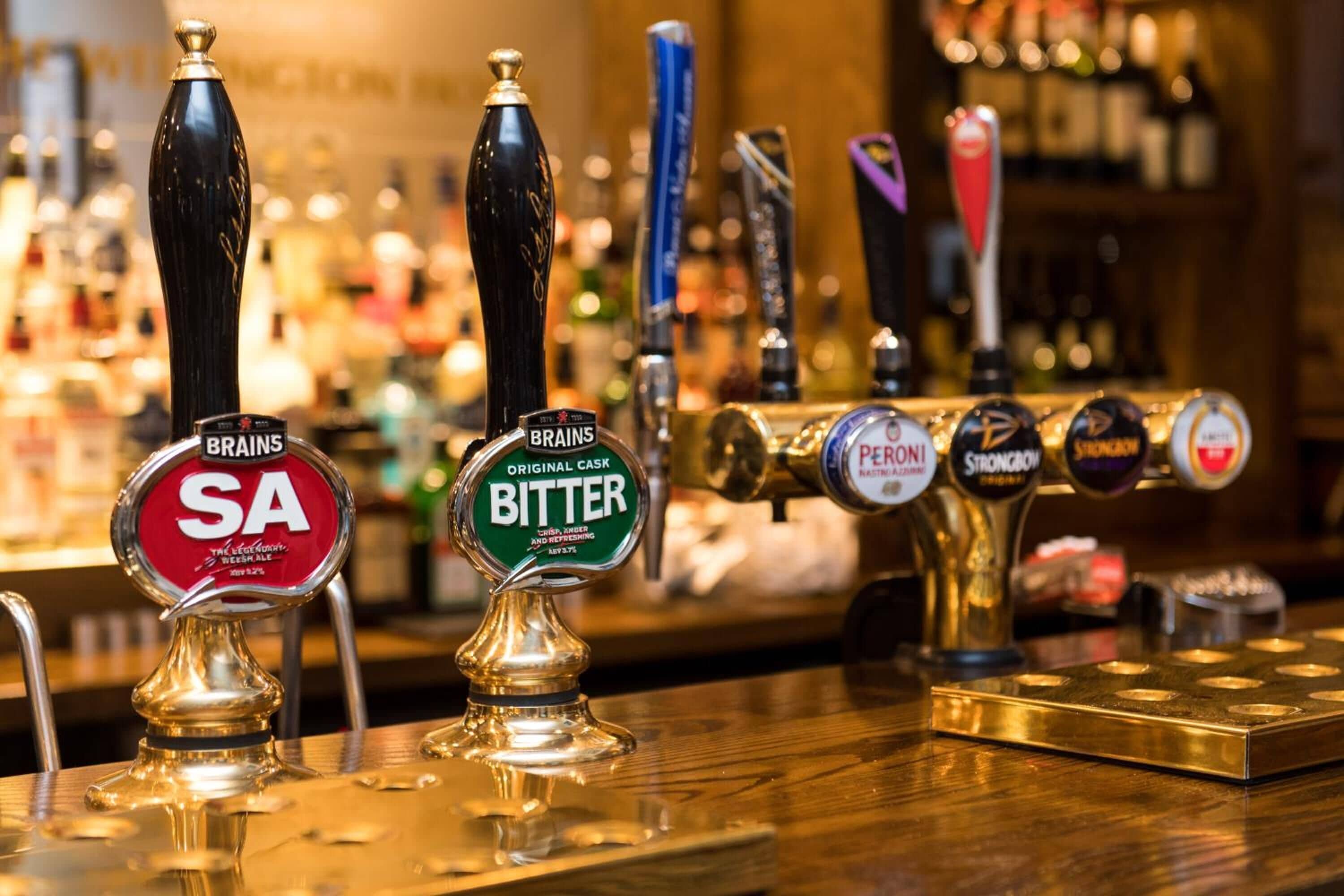 A bar with multiple beer taps, including brands like SA, BRATONS, and PERONI.