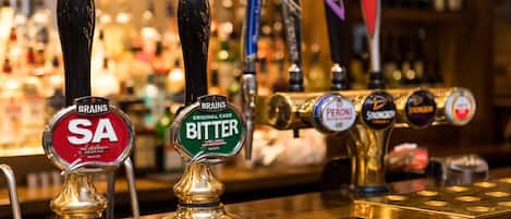 A bar with multiple beer taps, including brands like SA, BRATONS, and PERONI.