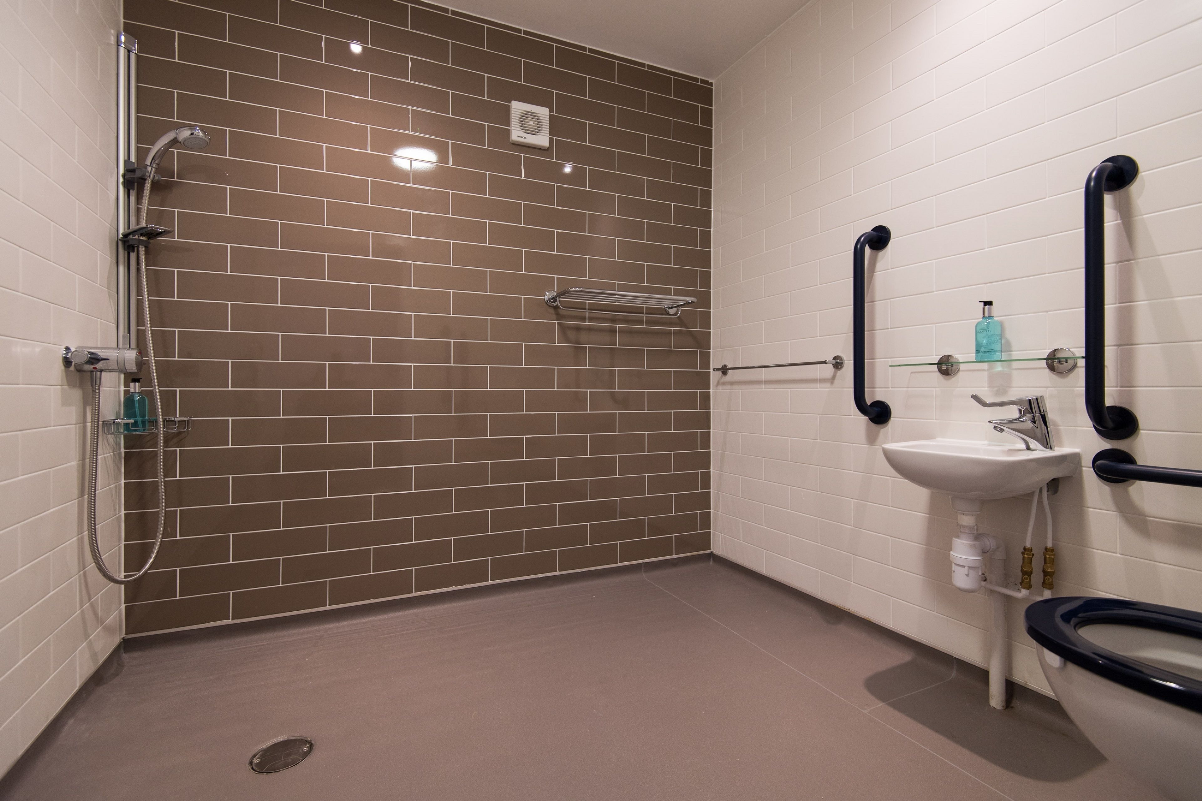 Ein Badezimmer mit Dusche, Waschbecken und Toilette.