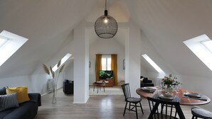 A modern loft apartment with a dining area, a living room, and a view of the outdoors. - Hotel Obermaier (Munich)
