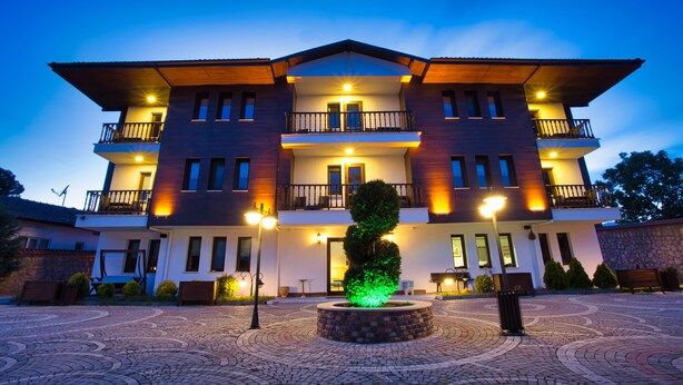 A multi-story hotel with a central courtyard, balconies, and a well-lit entrance. - Hıdırlık Konakları (Safranbolu)