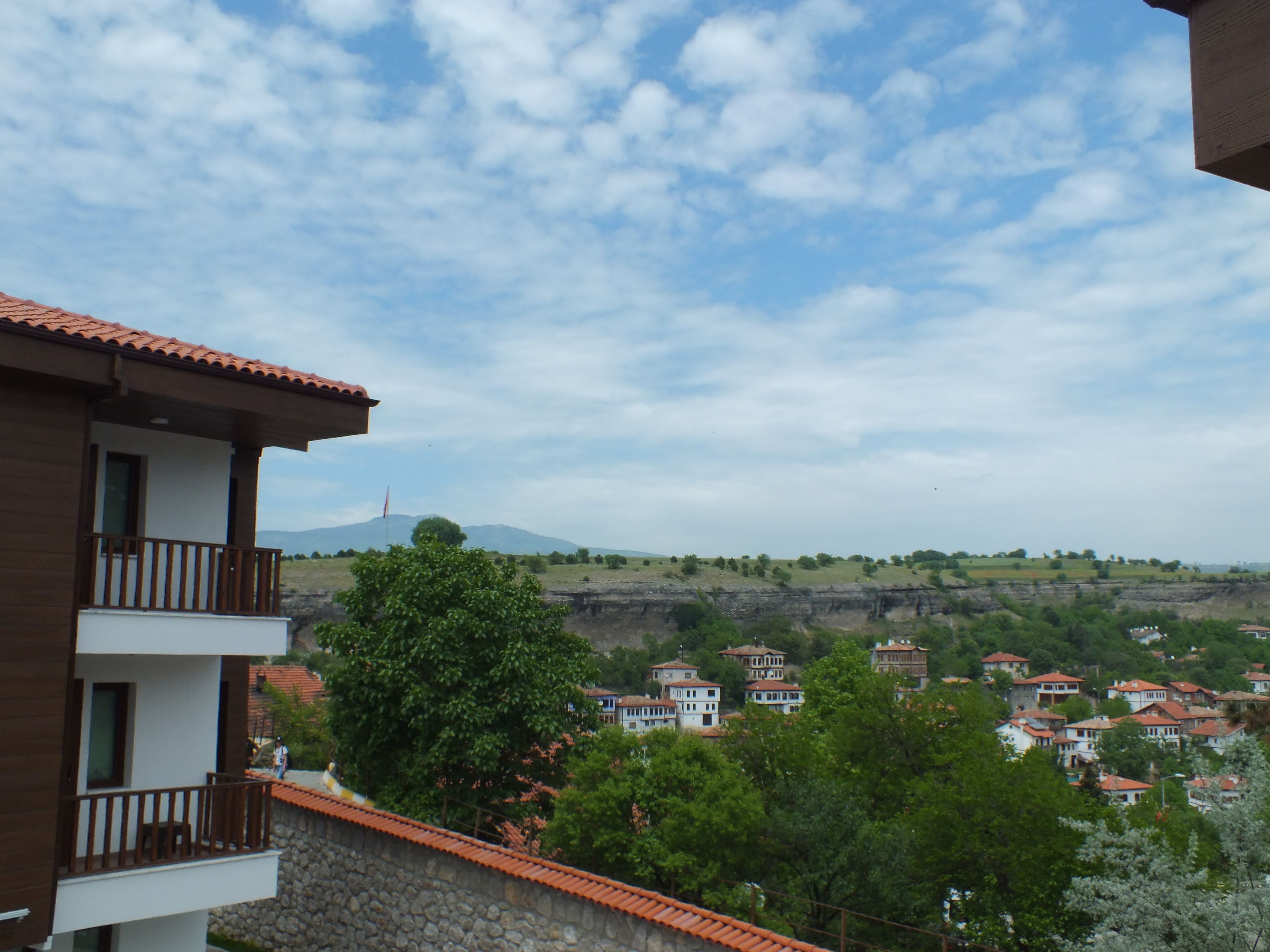 Ein Wohngebiet mit Blick auf einen entfernten Berg, umgeben von Grünflächen und Häusern mit roten Ziegeldächern.