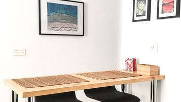 Una cocina moderna con encimera de madera, sillas negras y un cuadro enmarcado.