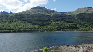 A lake surrounded by green hills and mountains. - TwoStones (Arrochar)