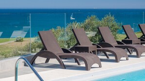 A poolside area with lounge chairs and a view of the ocean. - The Links I 2226 Golf & Sea views (La Alcaidesa)