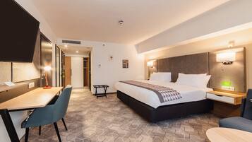 Una habitación de hotel moderna con una cama grande, un escritorio y una silla.