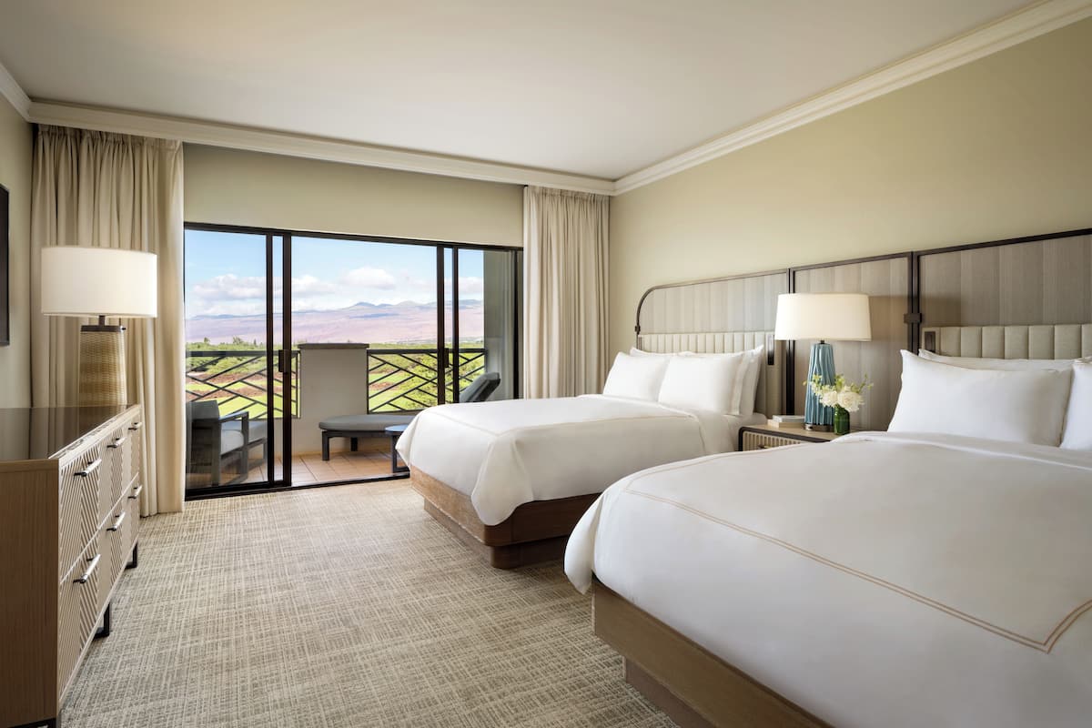 A hotel room with two beds, a desk, a chair, and a view of the outdoors.
