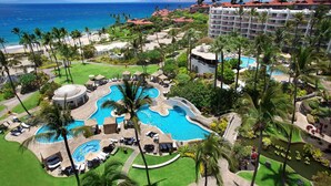 A resort with multiple swimming pools, palm trees, and a view of the ocean. - Fairmont Kea Lani Maui Villa Experience (Kihei)