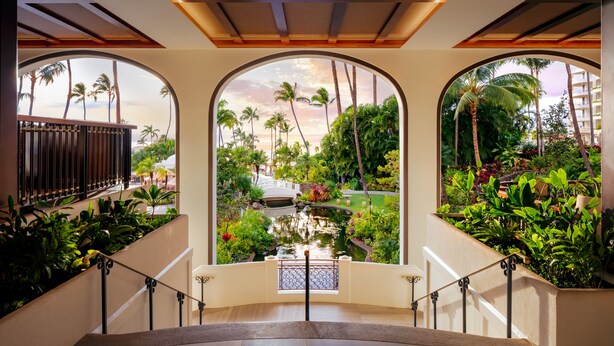 A staircase with a view of a garden, palm trees, and a bridge. - Fairmont Kea Lani Maui Villa Experience (Kihei)