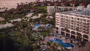 A resort with multiple buildings, a swimming pool, and a view of the ocean. - Fairmont Kea Lani Maui Villa Experience (Kihei)