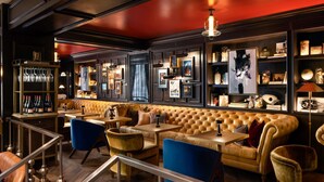 A bar area with leather seating, a staircase, and a herringbone wood floor. - Fairmont Royal York Gold Experience (Toronto)