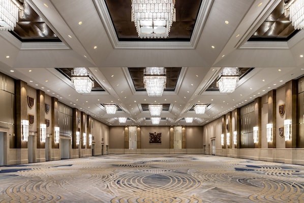 A spacious, well-lit conference room with a patterned carpet, chandeliers, and wall-mounted lights. - Fairmont Royal York Gold Experience (Toronto)