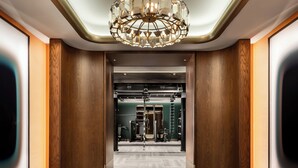 A modern hotel lobby with a geometric marble floor, a central chandelier, and wooden paneling. - Fairmont Royal York Gold Experience (Toronto)