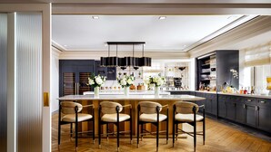 A modern kitchen with a central island, bar stools, and a dining area. - Fairmont Royal York Gold Experience (Toronto)