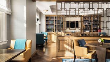A modern interior with a wooden dining table, chairs, and a decorative partition.