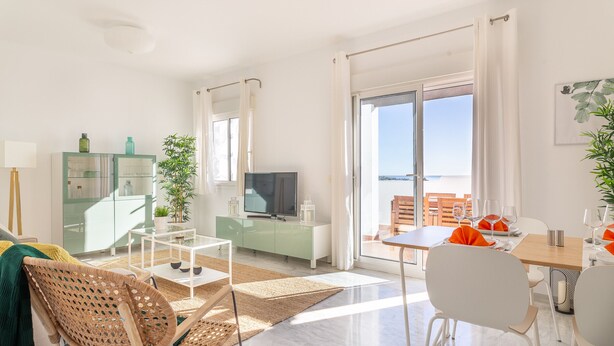 A modern living room with a TV, dining area, and large windows. - Valle Romano Prestigious 2266 (Estepona)