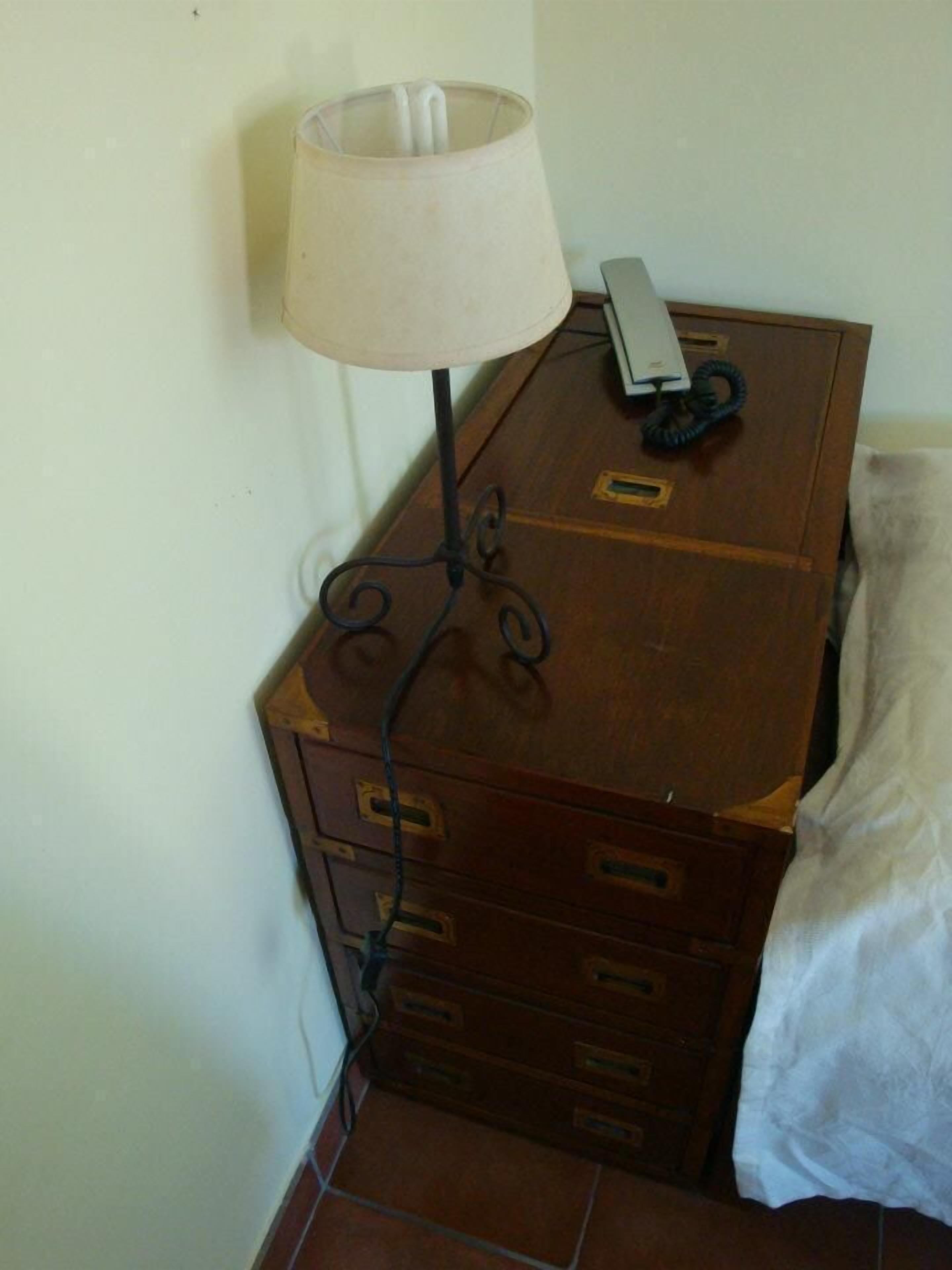 A wooden dresser with multiple drawers and a lamp on top.