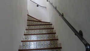 A staircase with patterned tiles and wooden handrails, leading to an upper floor. - Mini-villa No. 2 - 2/4 people (PORTO VECCHIO)