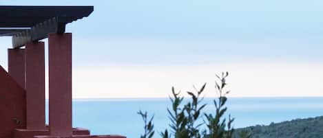 Un immeuble à la façade rouge qui offre une vue sur la mer.