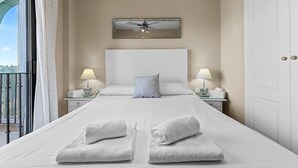 A hotel room with a large bed, two bedside tables with lamps, a ceiling fan, and a view through a balcony door. - Marina Duquesa 2110 Lovely Place (Manilva)