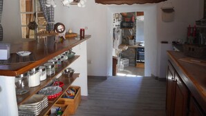 Een keuken met houten planken, hanggerei en een rustieke inrichting.