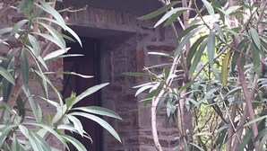 Un bâtiment en pierre avec une porte en bois et une entrée en briques.