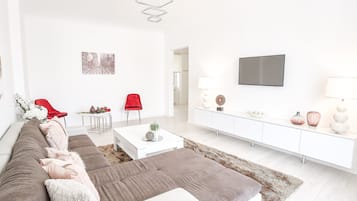 Appartamento Deluxe, vista città | Area soggiorno | TV a schermo piatto