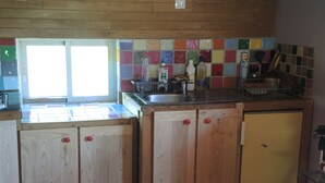 Una cocina con armarios de madera, salpicadero de azulejos y una ventana.