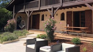 A two-story building with a balcony, outdoor seating, and a patio area.