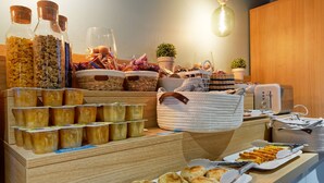 A breakfast buffet with various food items, including yogurt, cereal, and pastries, displayed on a wooden counter. - Kyriad Direct Saint Brieuc - Parc des Expositions (Tregueux)