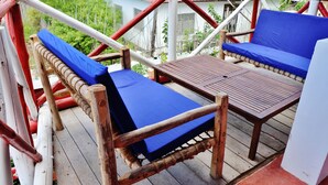 Eine Holzterrasse mit zwei blauen Sitzbereichen und einem kleinen Tisch.