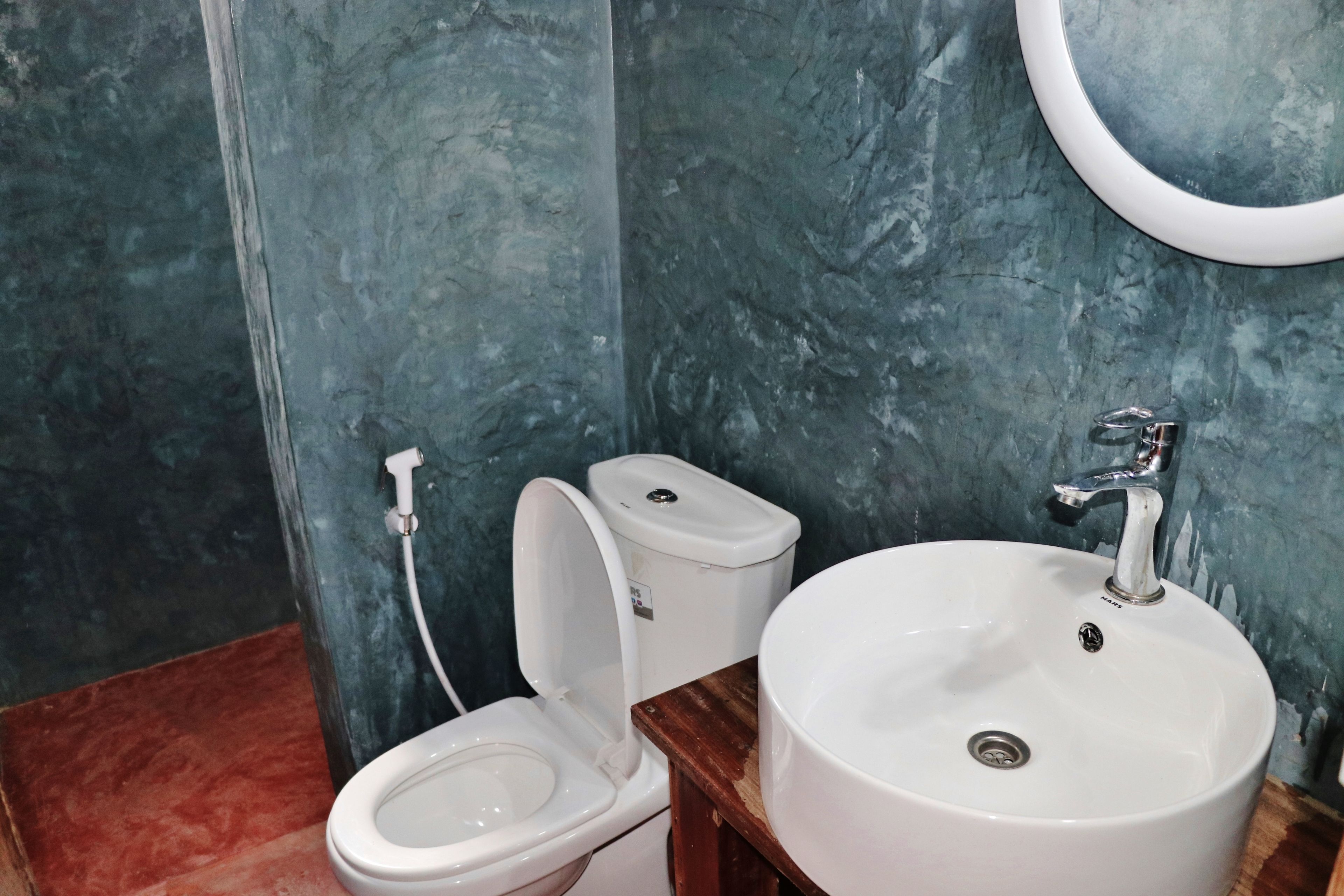 Une salle de bain avec des toilettes, un lavabo et un miroir.