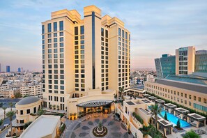 A high-rise hotel with a central courtyard, multiple floors, and a pool area. - The St. Regis Amman (Amman)