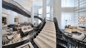 A spacious lobby with a grand staircase, modern furniture, and large windows. - The St. Regis Amman (Amman)