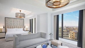 A modern hotel room with a bed, sofa, and round coffee table. - The St. Regis Amman (Amman)