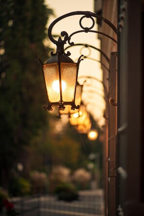 A row of hanging lanterns with a warm glow, attached to a metal structure. - Hotel Ristorante Alla Vittoria (Solferino)