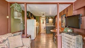 A compact living space with a kitchenette, a dining area, and a TV.