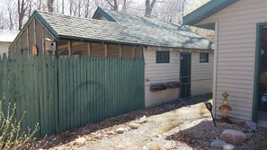 A small wooden structure with a green roof and a picket fence. - Hemlock Hide-A-Way Cozy Romantic Private Lake Cabin (Rice Lake)